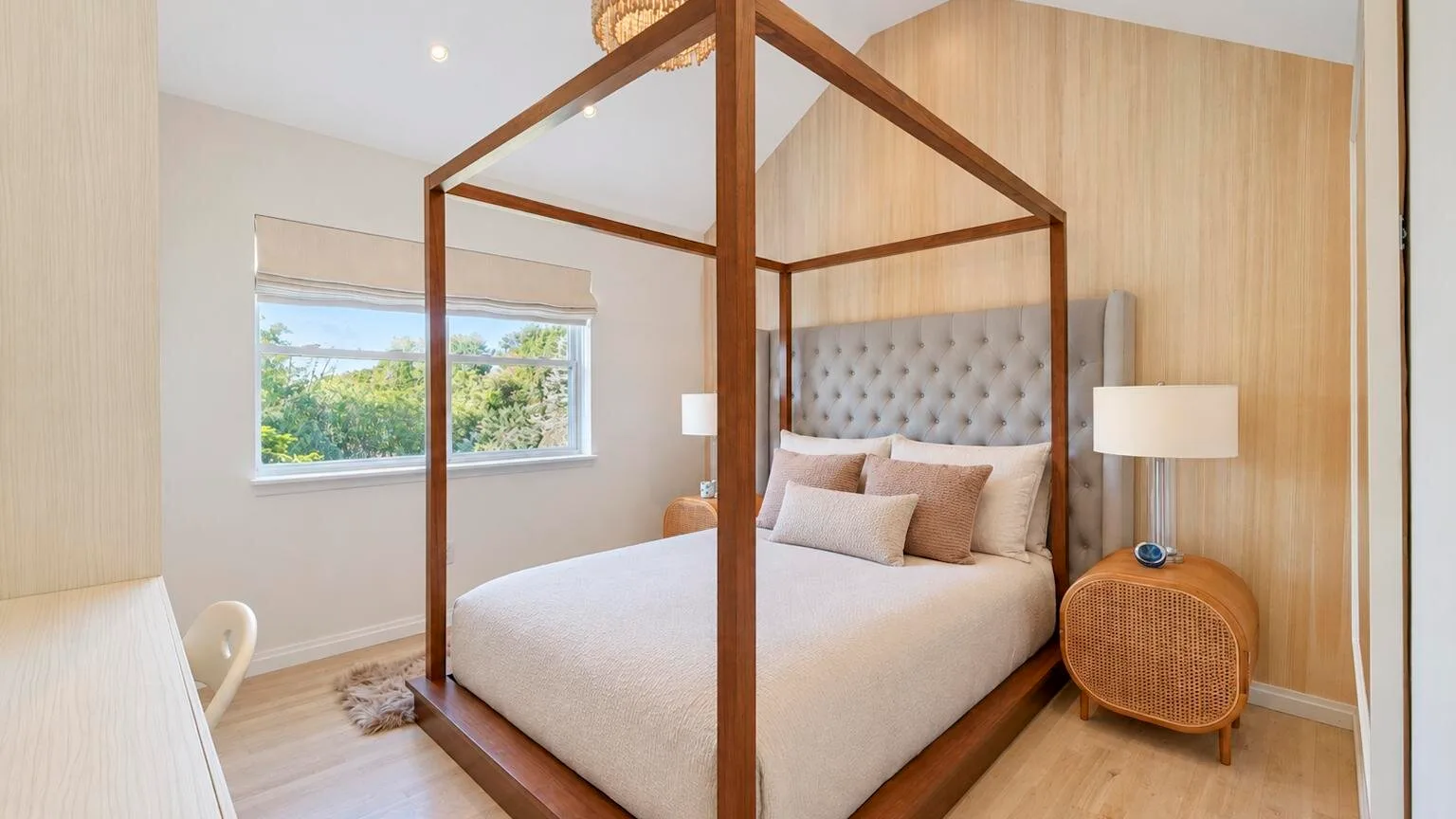 Un dormitorio con una cama con dosel y una ventana con vistas a la vegetación.