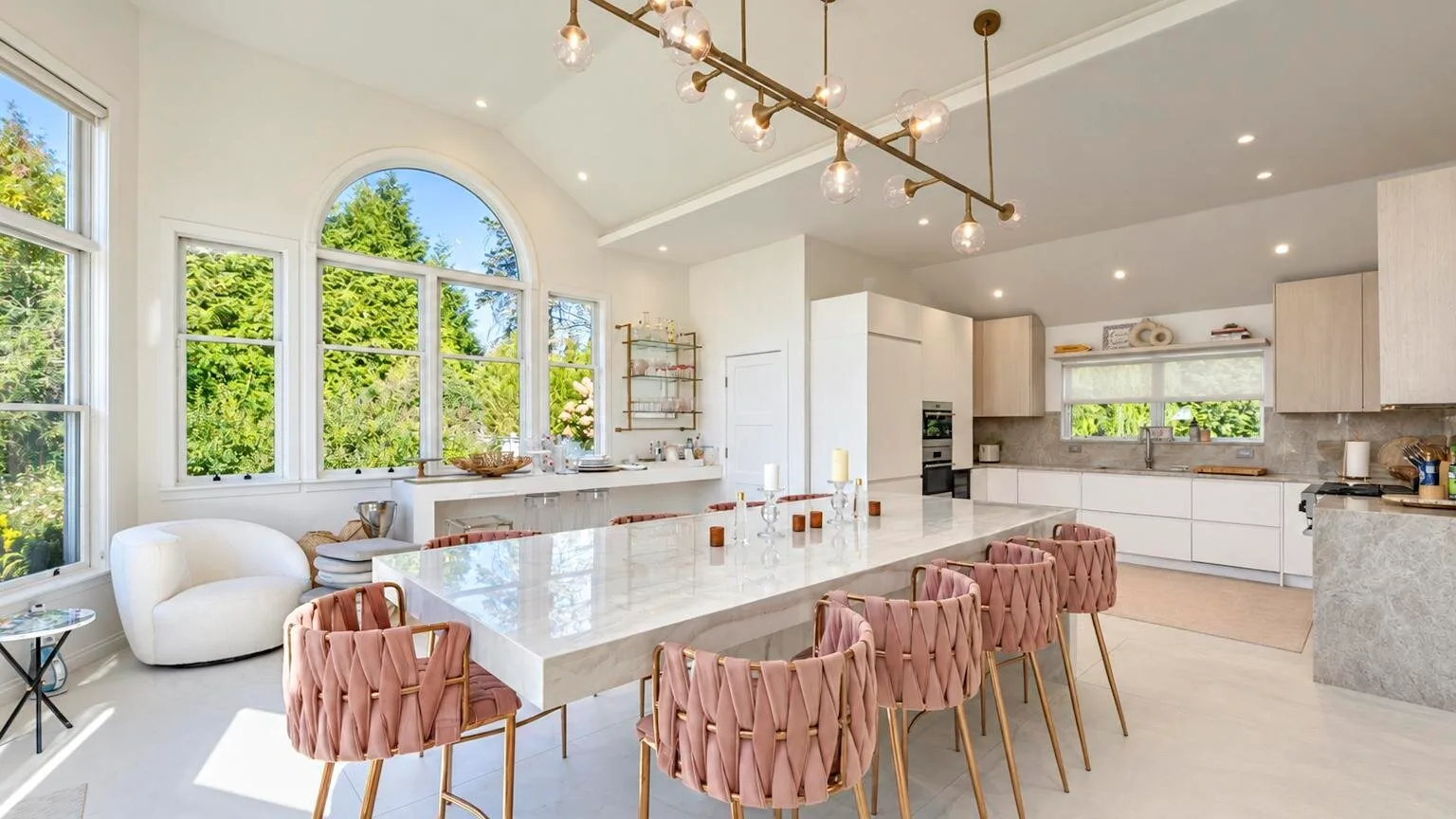 Cocina y comedor luminosos con una isla larga y ventanas amplias.