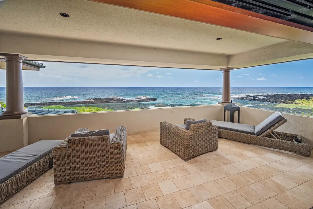 A covered outdoor seating area overlooks the ocean.