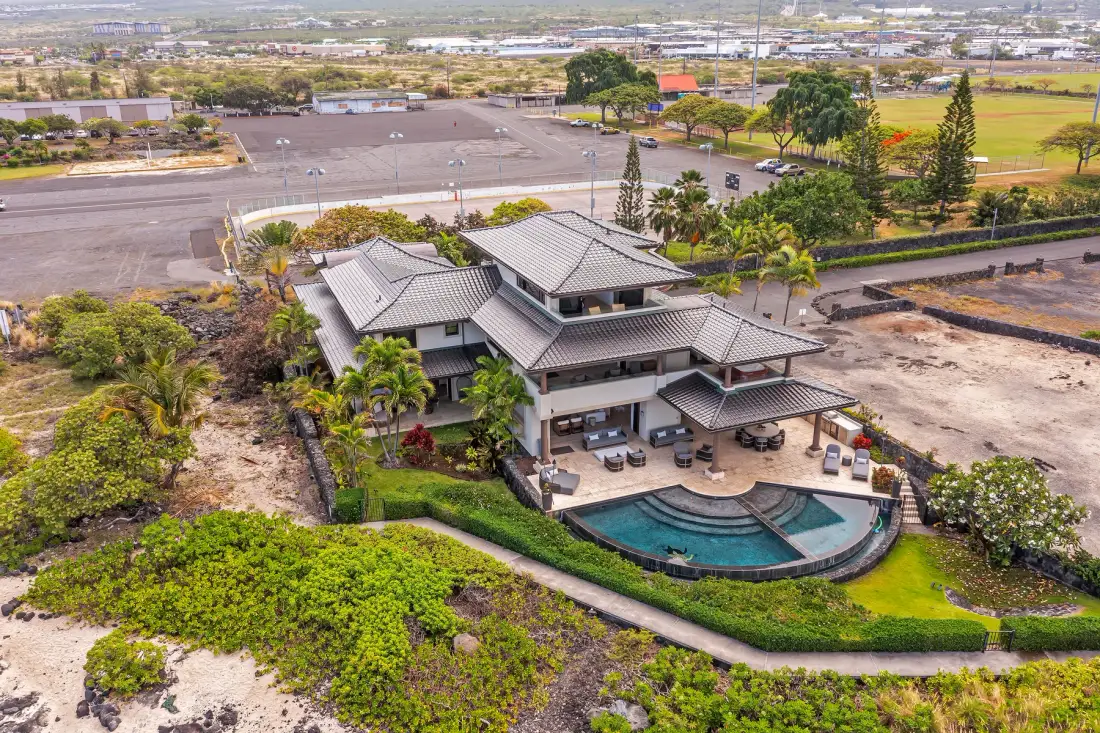 Aerial view of a large building with a swimming pool and landscaped grounds.
