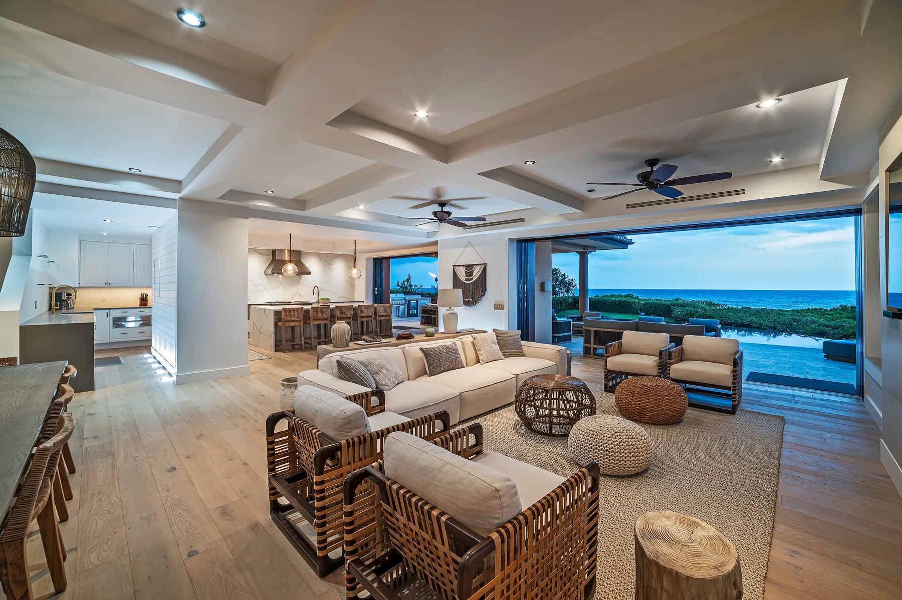 An open-plan living room with a dining area and wide windows overlooking the water.