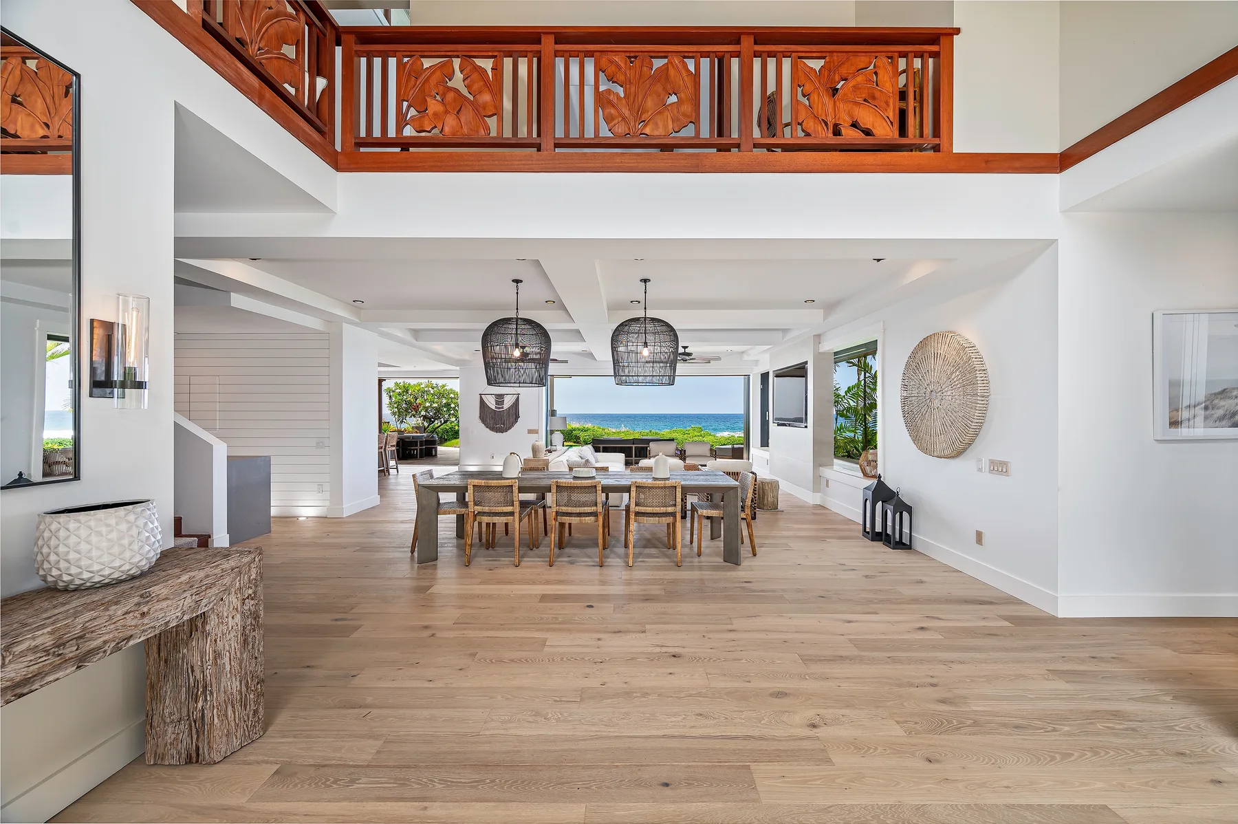 An open dining area with a long wooden table and ocean views.