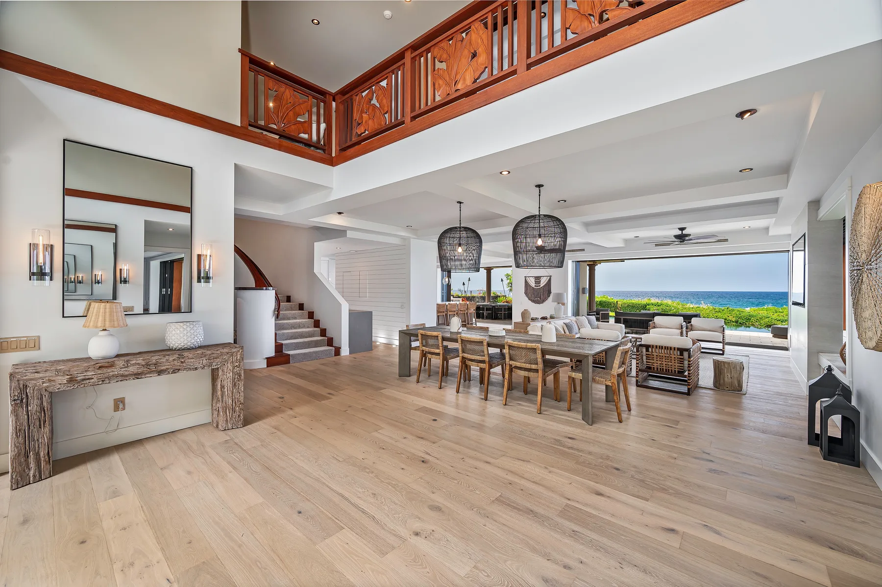 An open living and dining area with a long table and ocean views.