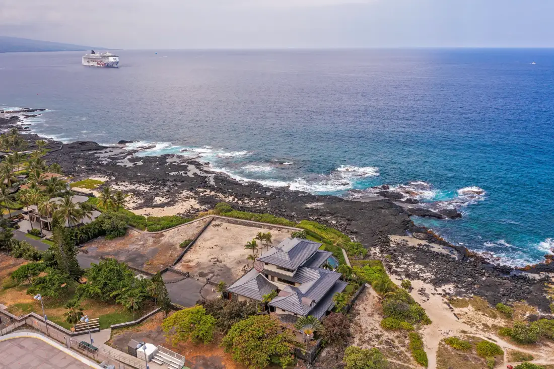 A coastal property overlooks a rocky shoreline and the ocean.