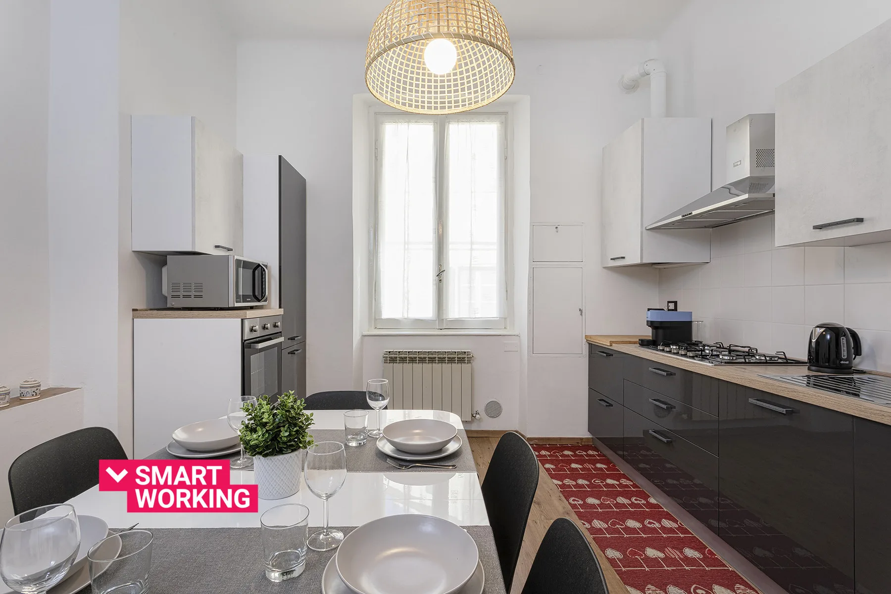 A bright kitchen and dining area with a table beneath a woven pendant light.