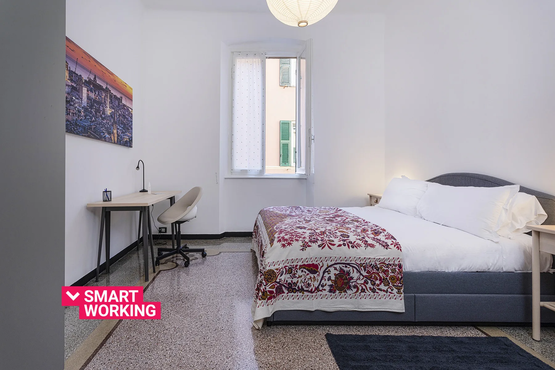 Un dormitorio con una cama, un escritorio y una ventana.