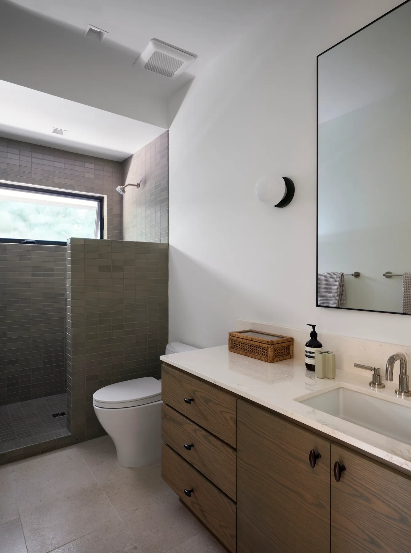 A modern bathroom with a walk-in shower and a wood vanity.