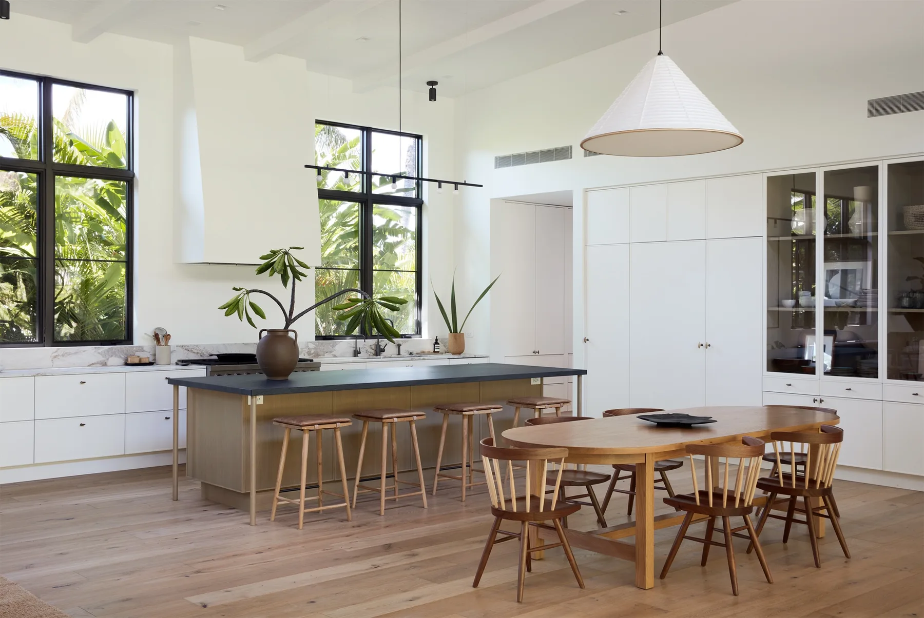 Una cocina luminosa con una isla central y una mesa de comedor de madera.