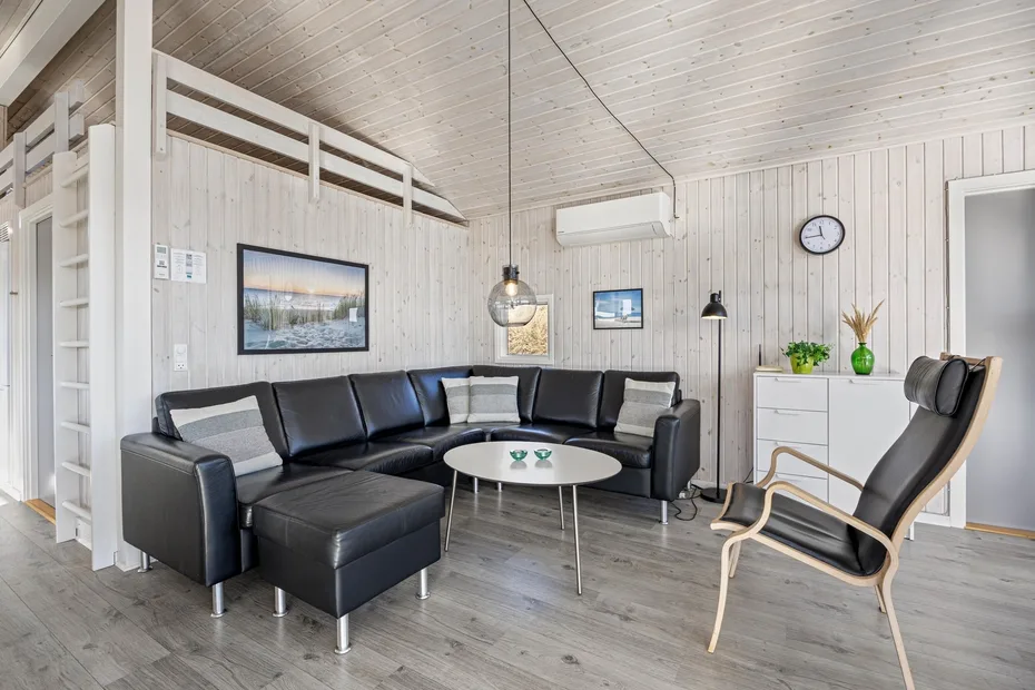 Una sala de estar con sofá seccional, mesa de centro y sillón.