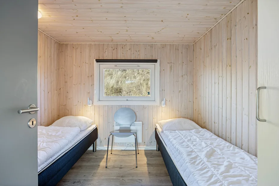 Un dormitorio pequeño con dos camas individuales y una ventana.