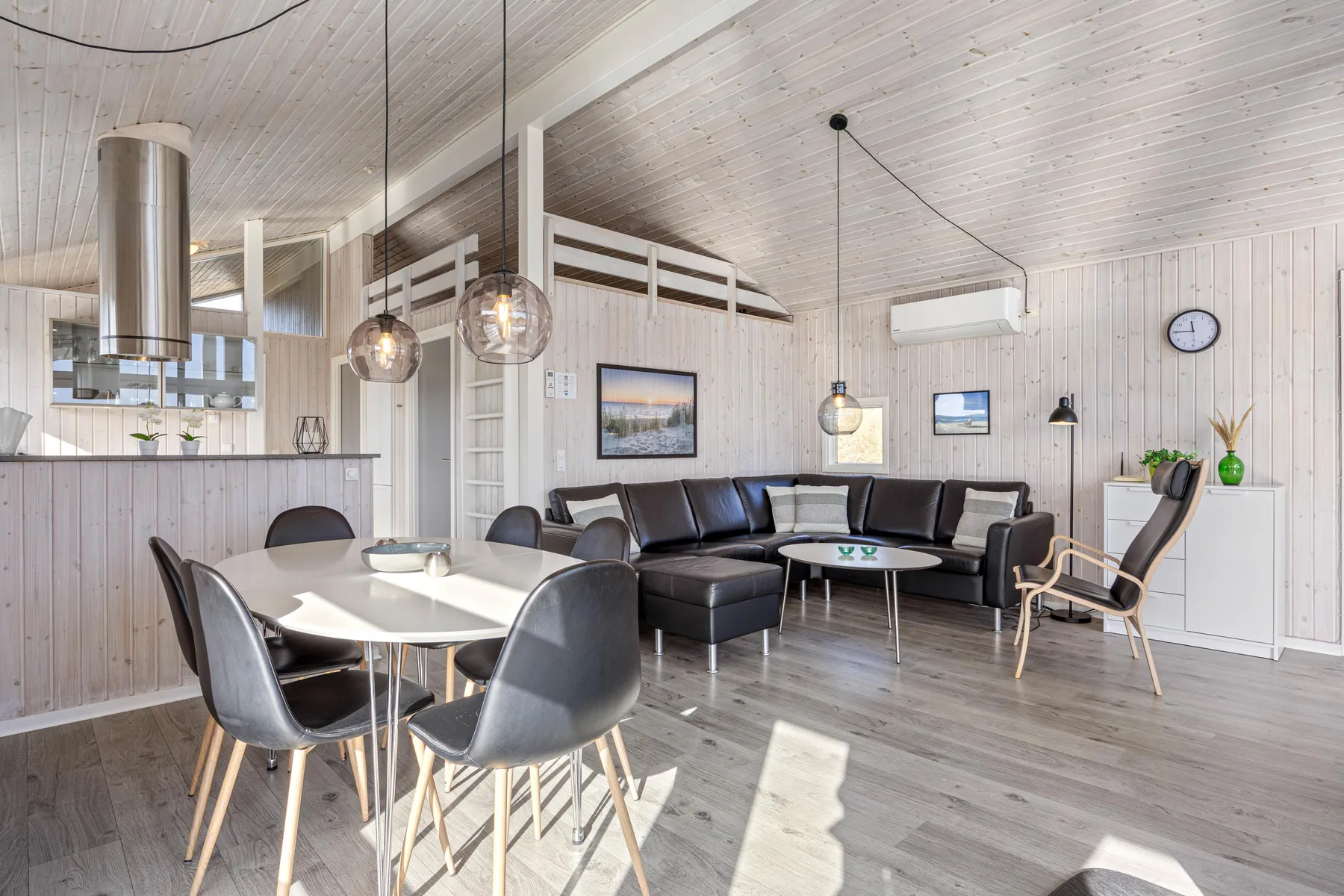 Una luminosa zona abierta de estar y comedor, con una barra de cocina y asientos.