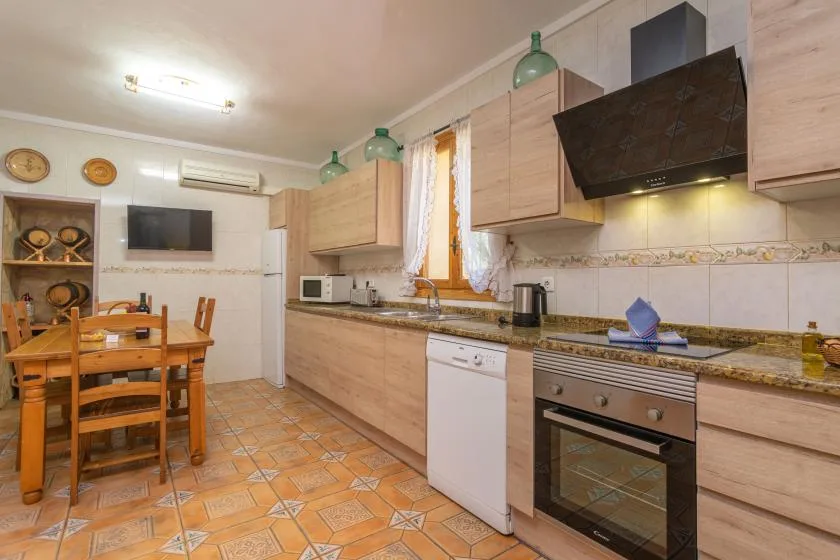 A kitchen and dining area with wooden cabinets, a table, and built-in appliances.