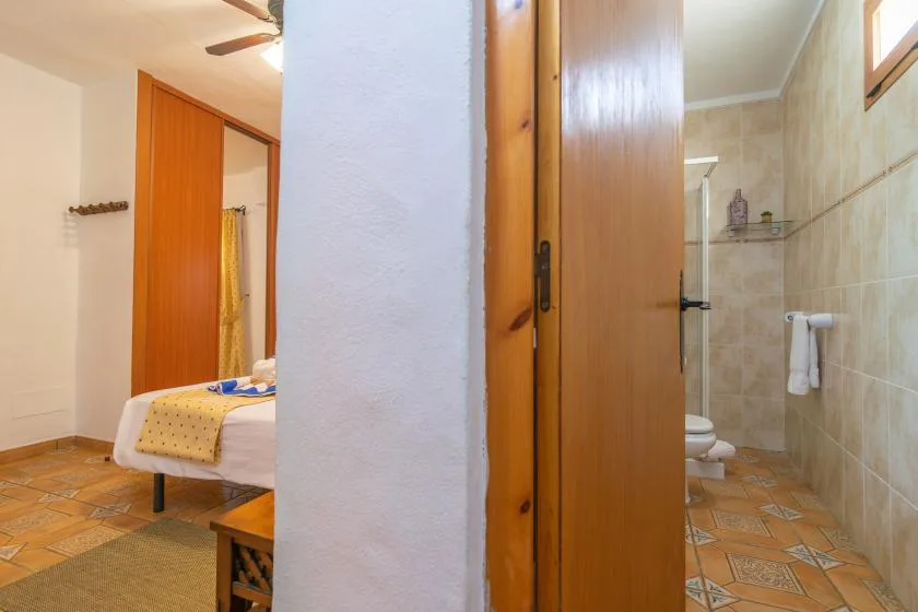 A bedroom and bathroom are visible through an open wooden doorway.