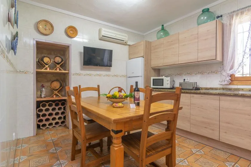 A kitchen and dining area with wooden cabinets, a table, and chairs.