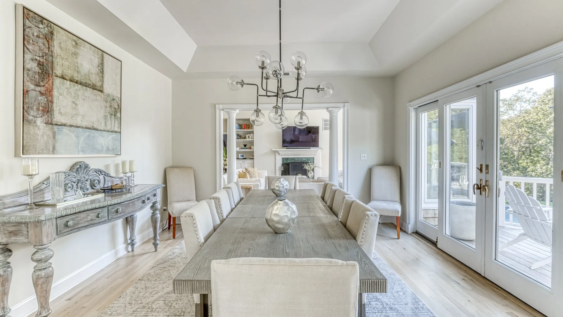 Un comedor luminoso con una mesa larga y puertas de vidrio hacia una terraza.