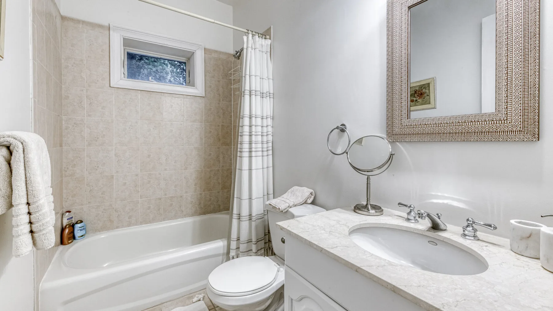 Un baño con bañera, cortina de ducha y lavabo.