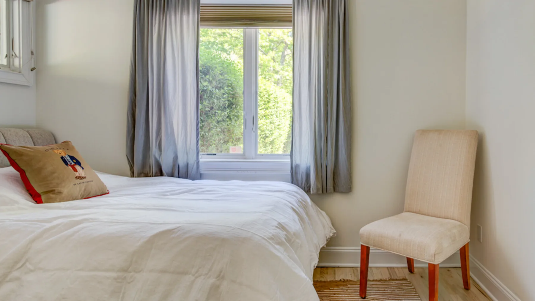 Un dormitorio con una cama, una ventana y una silla.