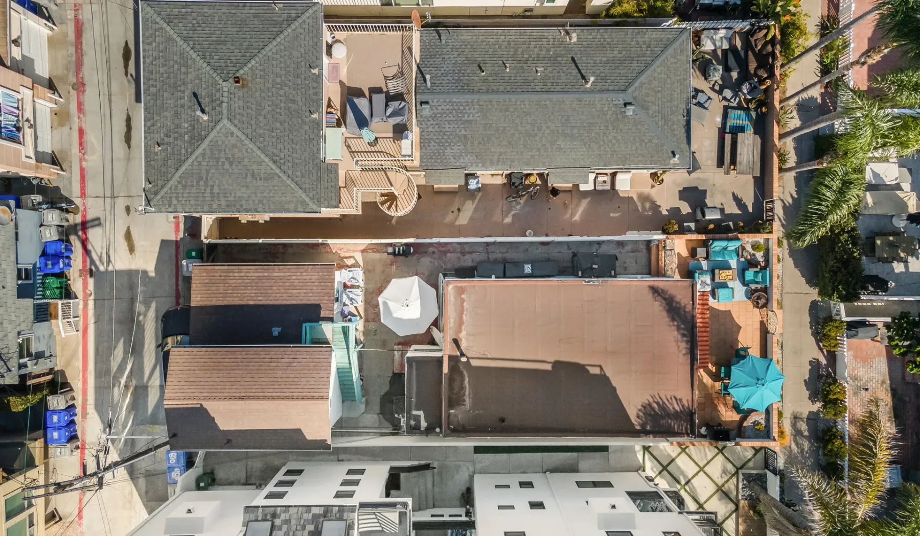An aerial view of a building complex with rooftops and a small outdoor seating area.