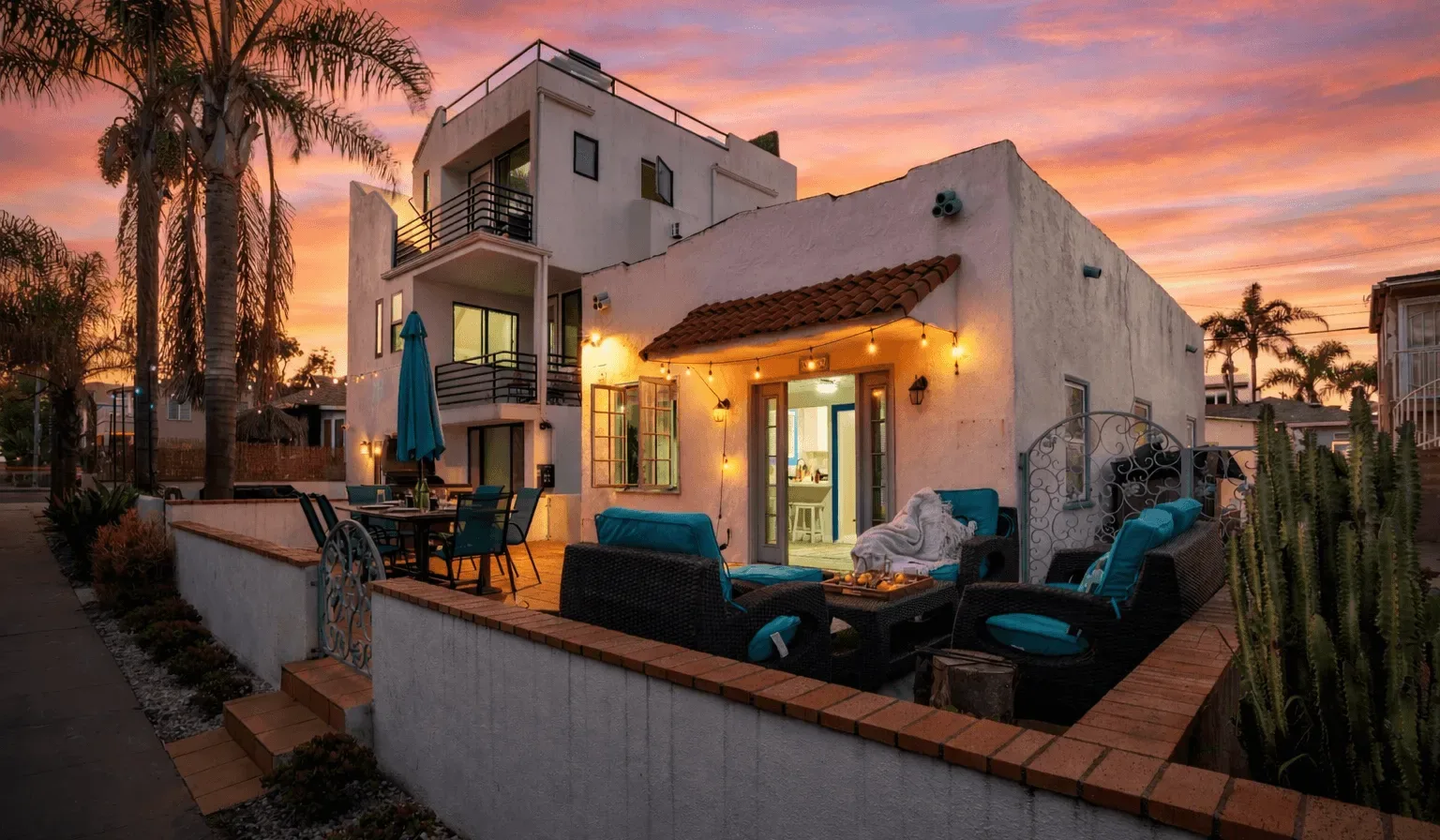 An outdoor patio with seating beside a stucco building at sunset.