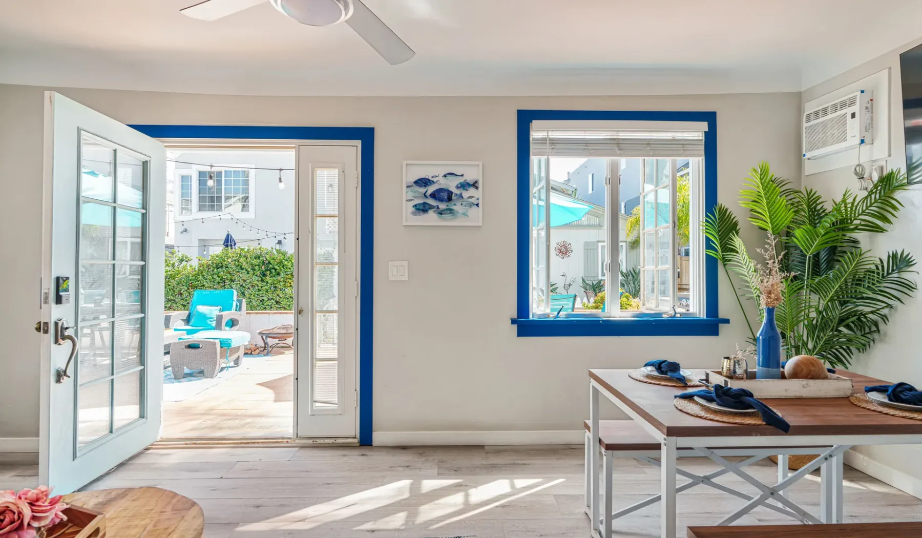 Una luminosa sala se abre a un patio por puertas de vidrio, con una ventana que da a la piscina.
