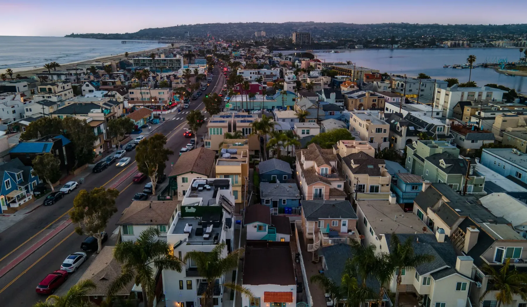 Aerial view of a coastal neighborhood with homes along a curving road.