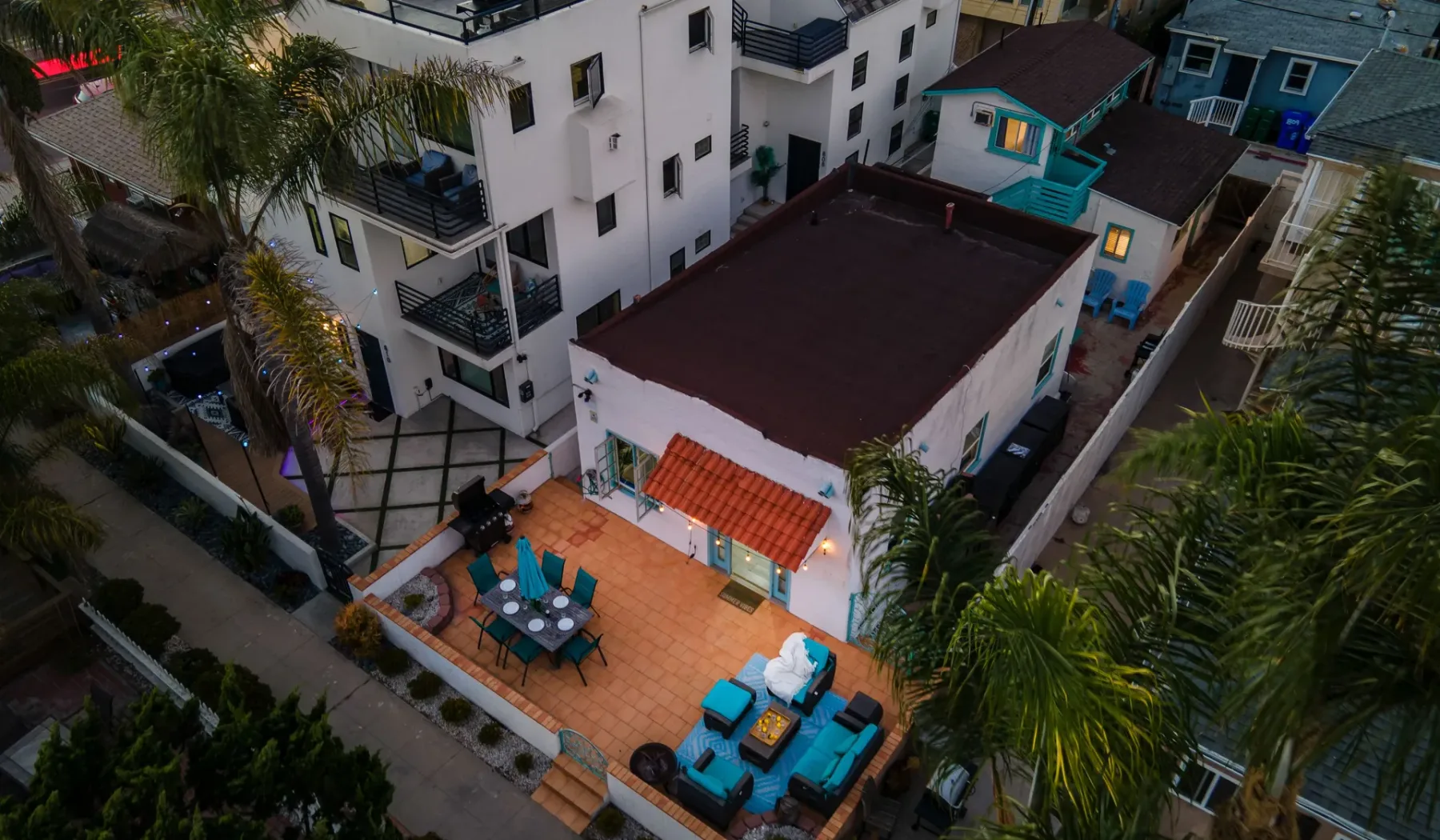 An aerial view shows a white building with a tiled outdoor seating patio.