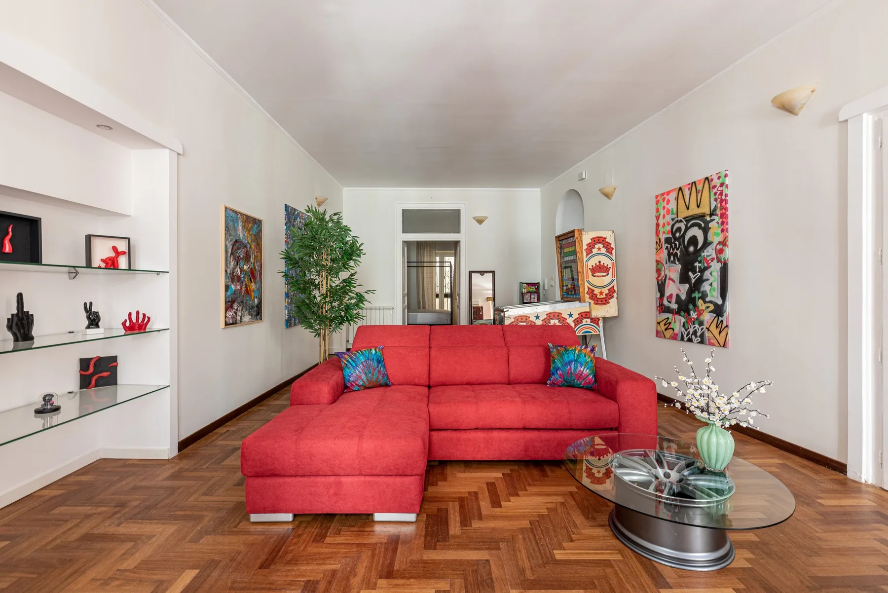 A living room with a red sectional sofa and a glass coffee table.
