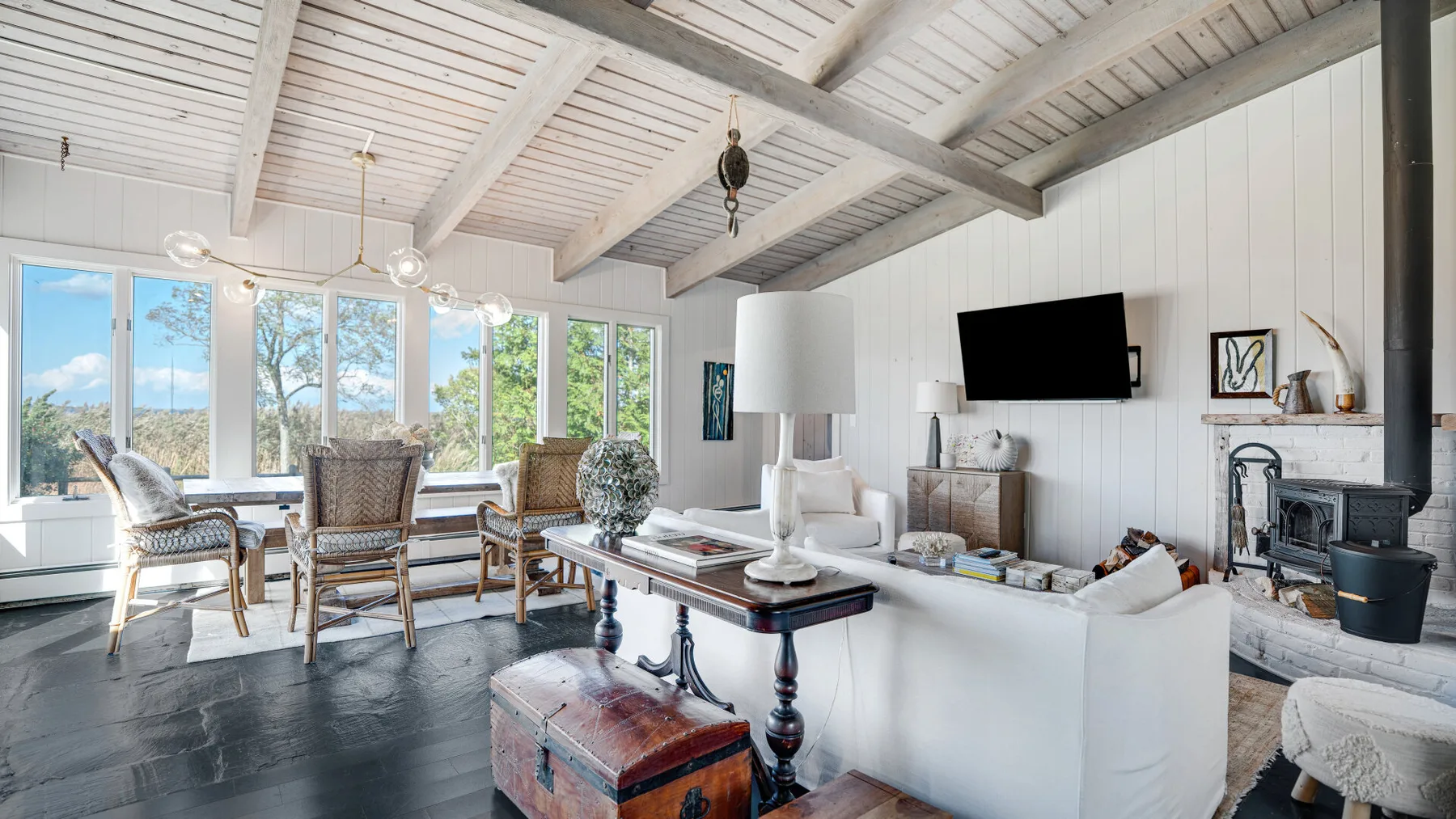 A bright living room with seating, a coffee table, and large windows.