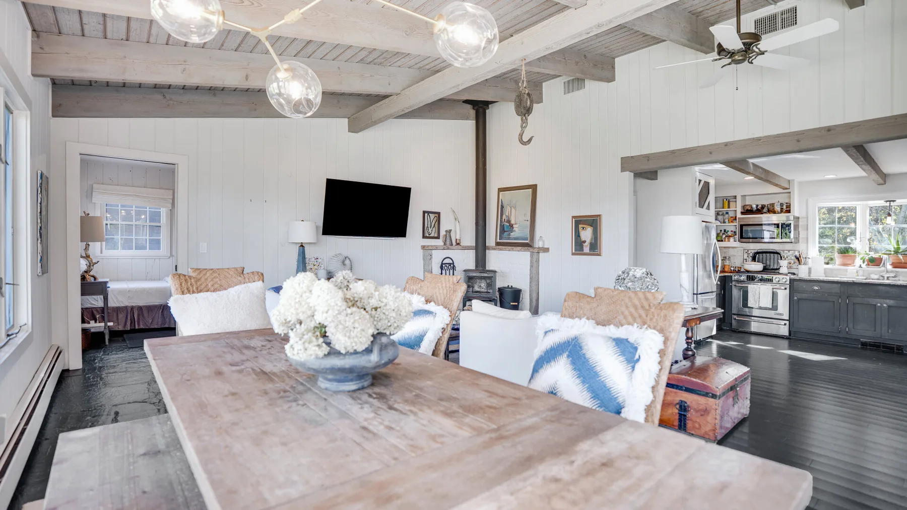 A bright open-plan dining and living area with a kitchen in the background.