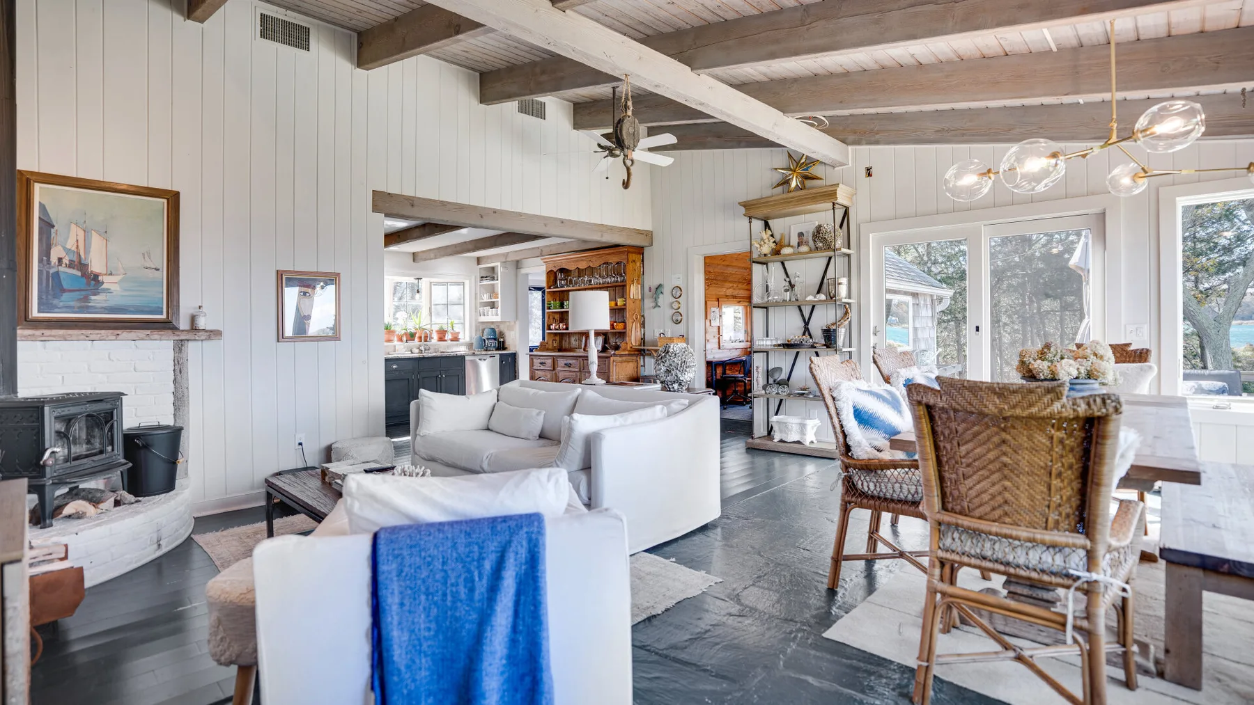 A bright living room with seating, a fireplace, and large windows.