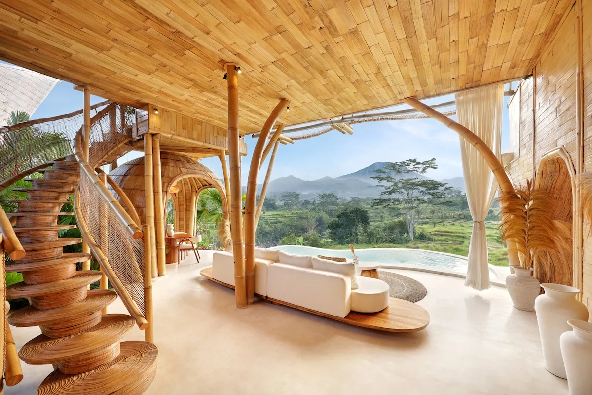 An open living area with curved seating and a wide view of green hills.