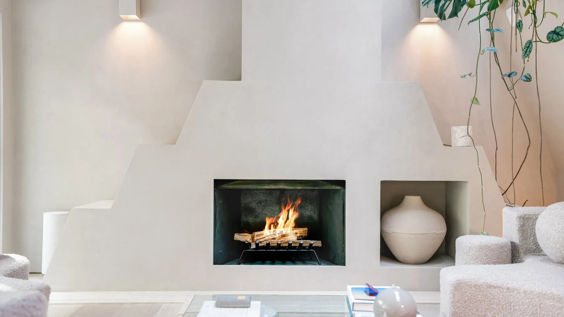 Una sala de estar moderna con una chimenea encendida y estantes empotrados.