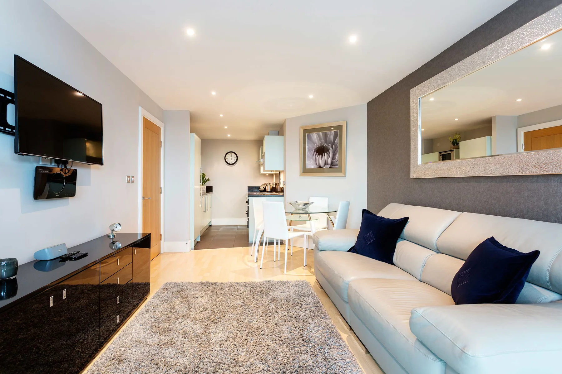 A bright living room with a light-colored sofa and dining table.