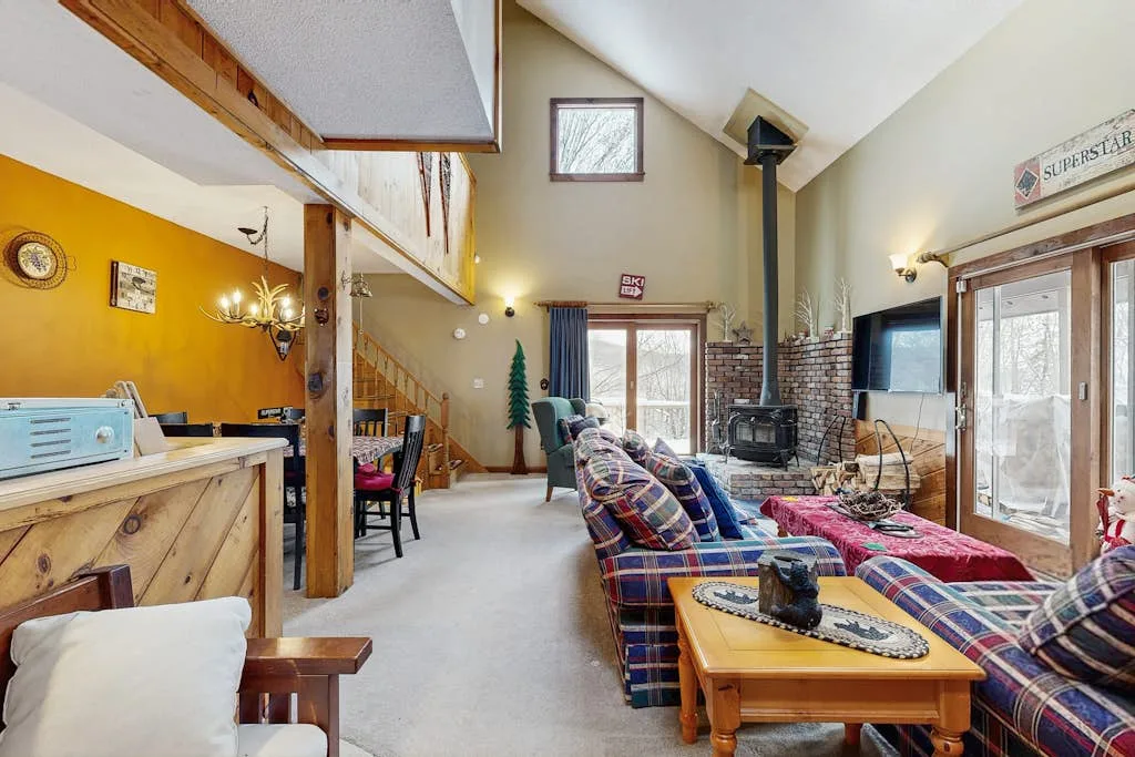 A spacious living room with a high sloped ceiling and seating around a coffee table.