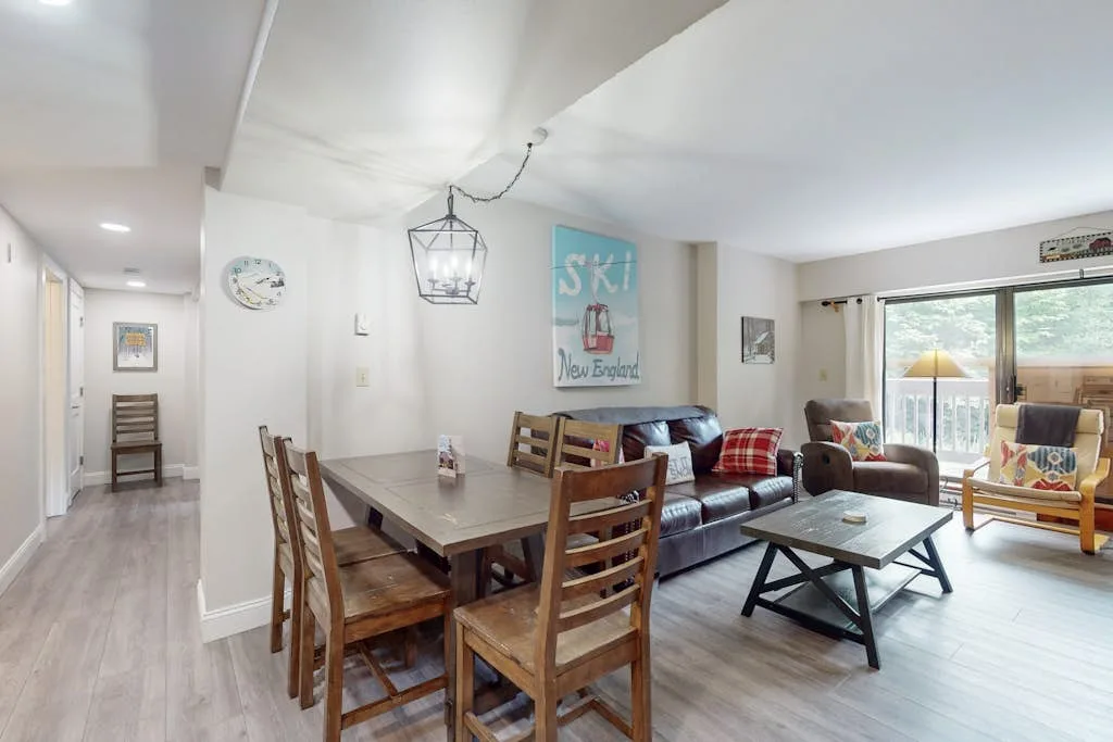 An open-plan living and dining area with a dining table and seating by the windows.