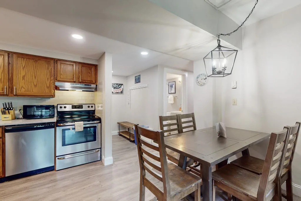 An open kitchen and dining area with wooden cabinets and a dining table.