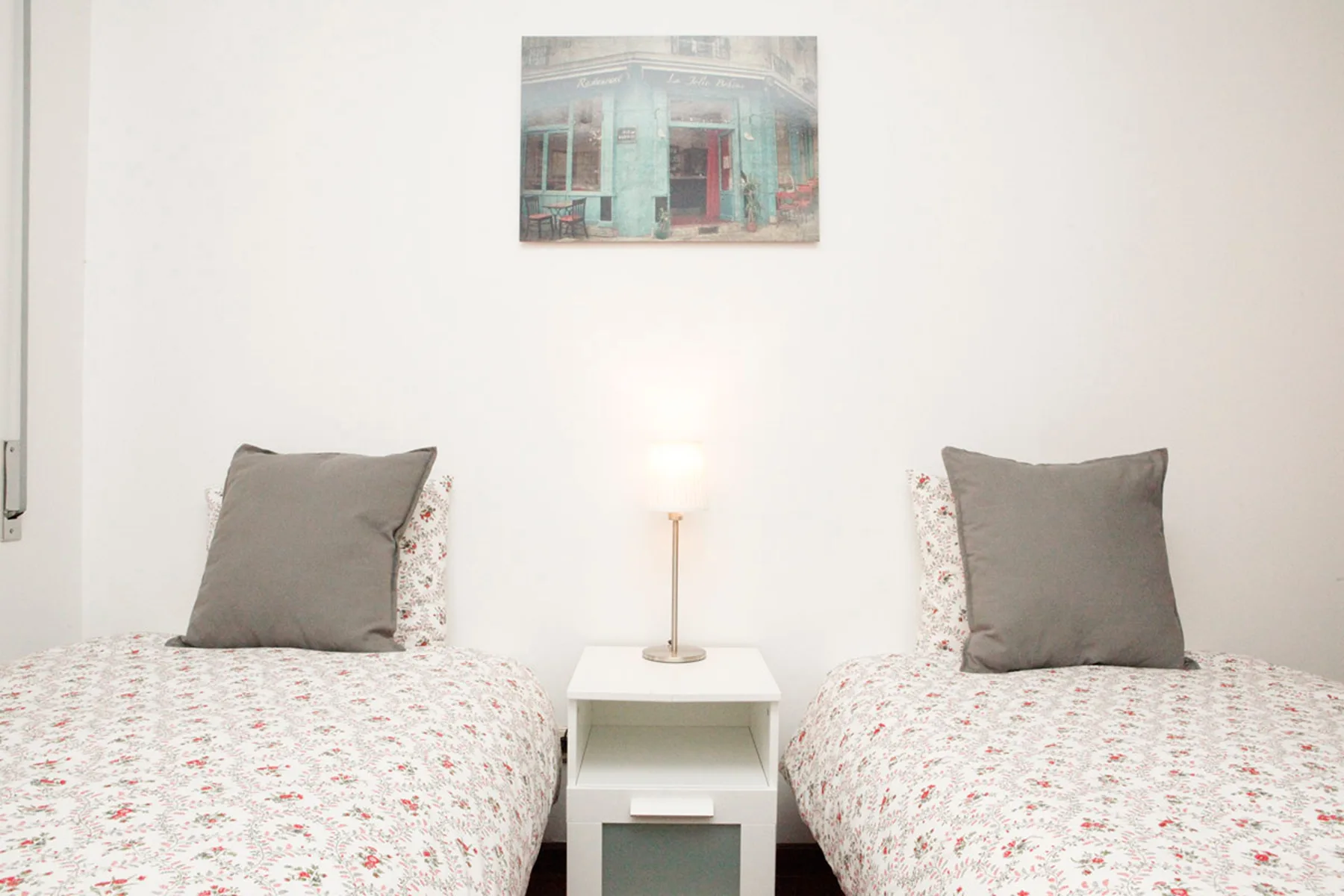 Un dormitorio con dos camas individuales y una mesita entre ellas.