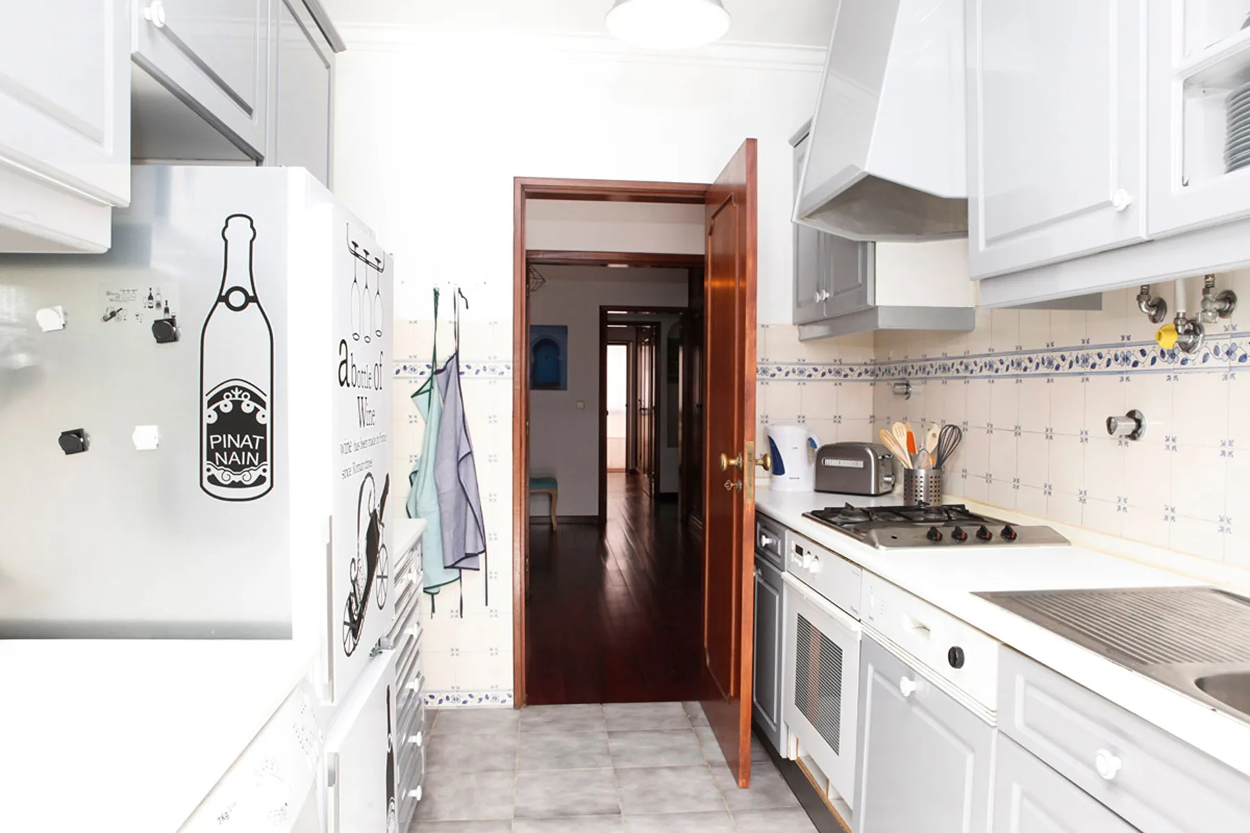 Una cocina luminosa con armarios blancos y una encimera junto a la pared.