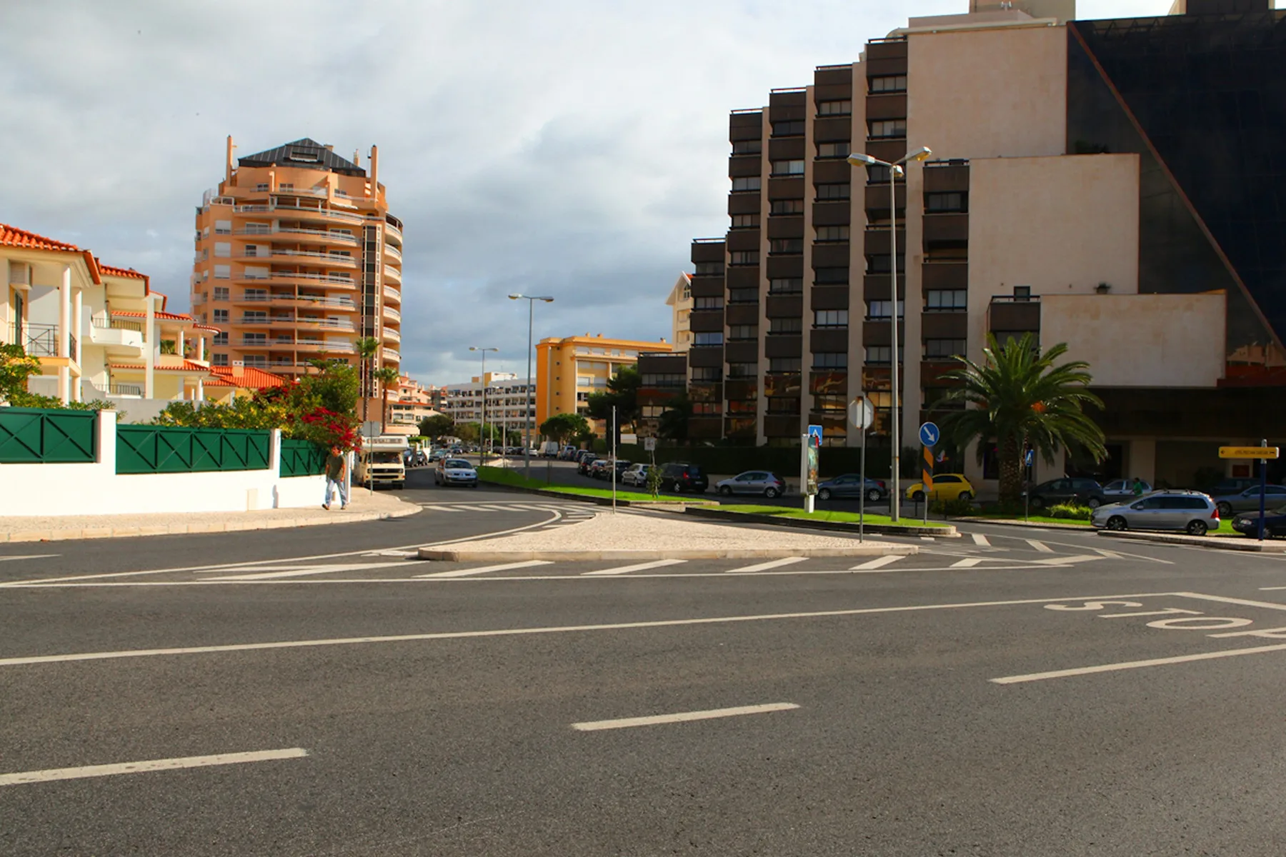 Una intersección urbana con edificios de apartamentos y coches.