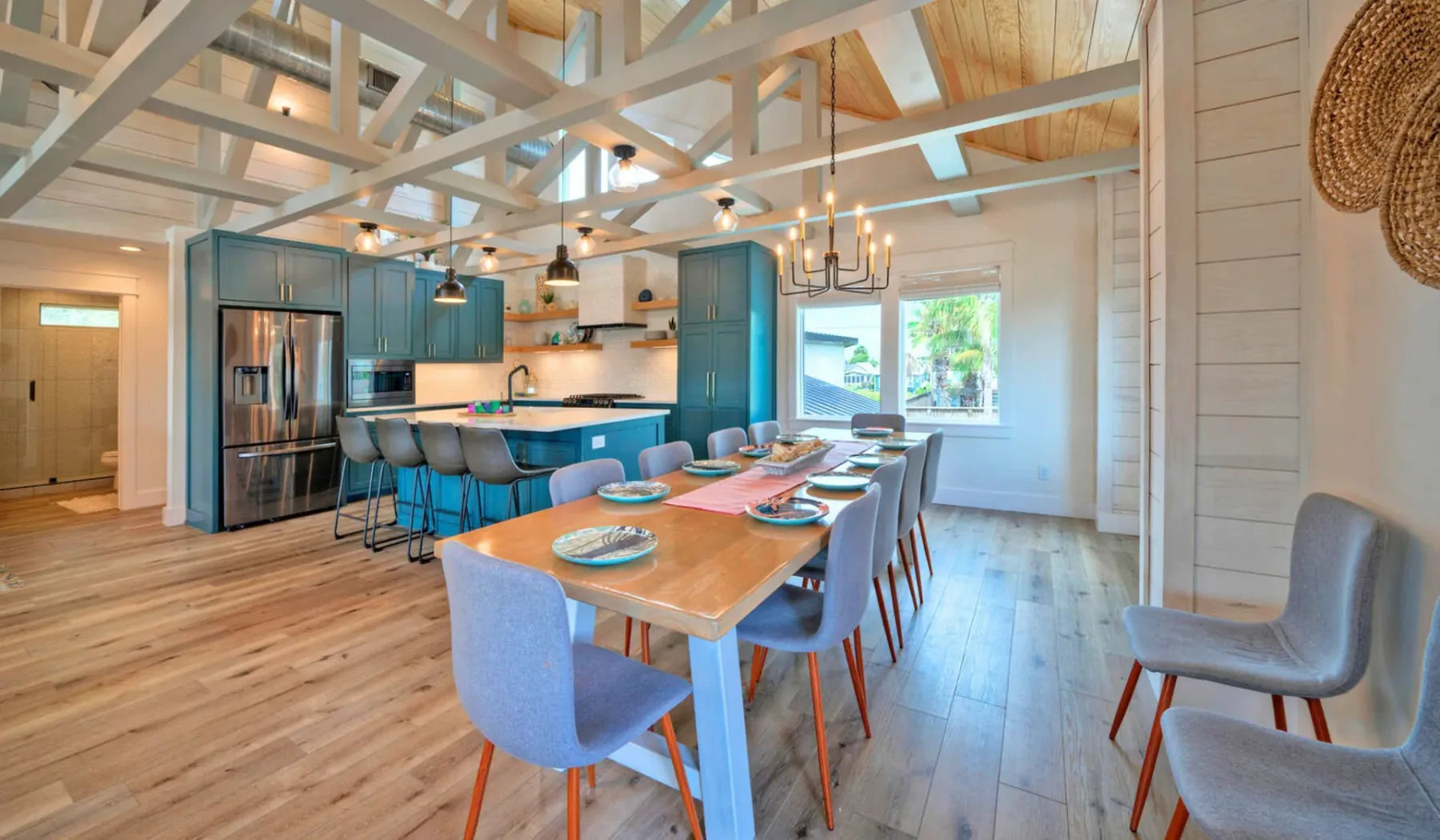 An open kitchen and dining area with a long table and blue cabinetry.