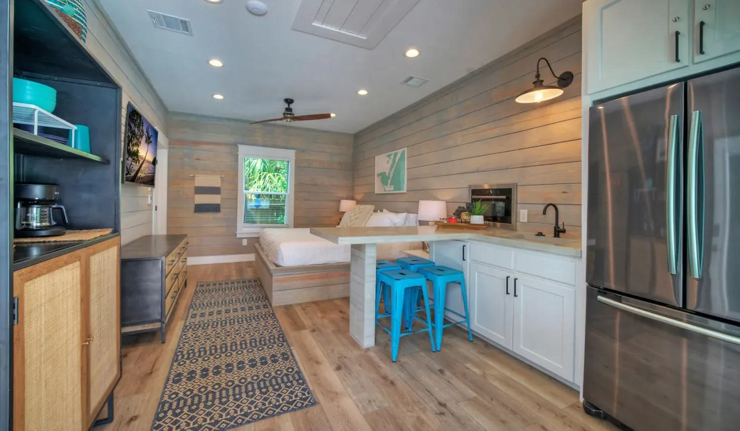 A compact kitchen and dining area with a counter and blue stools.