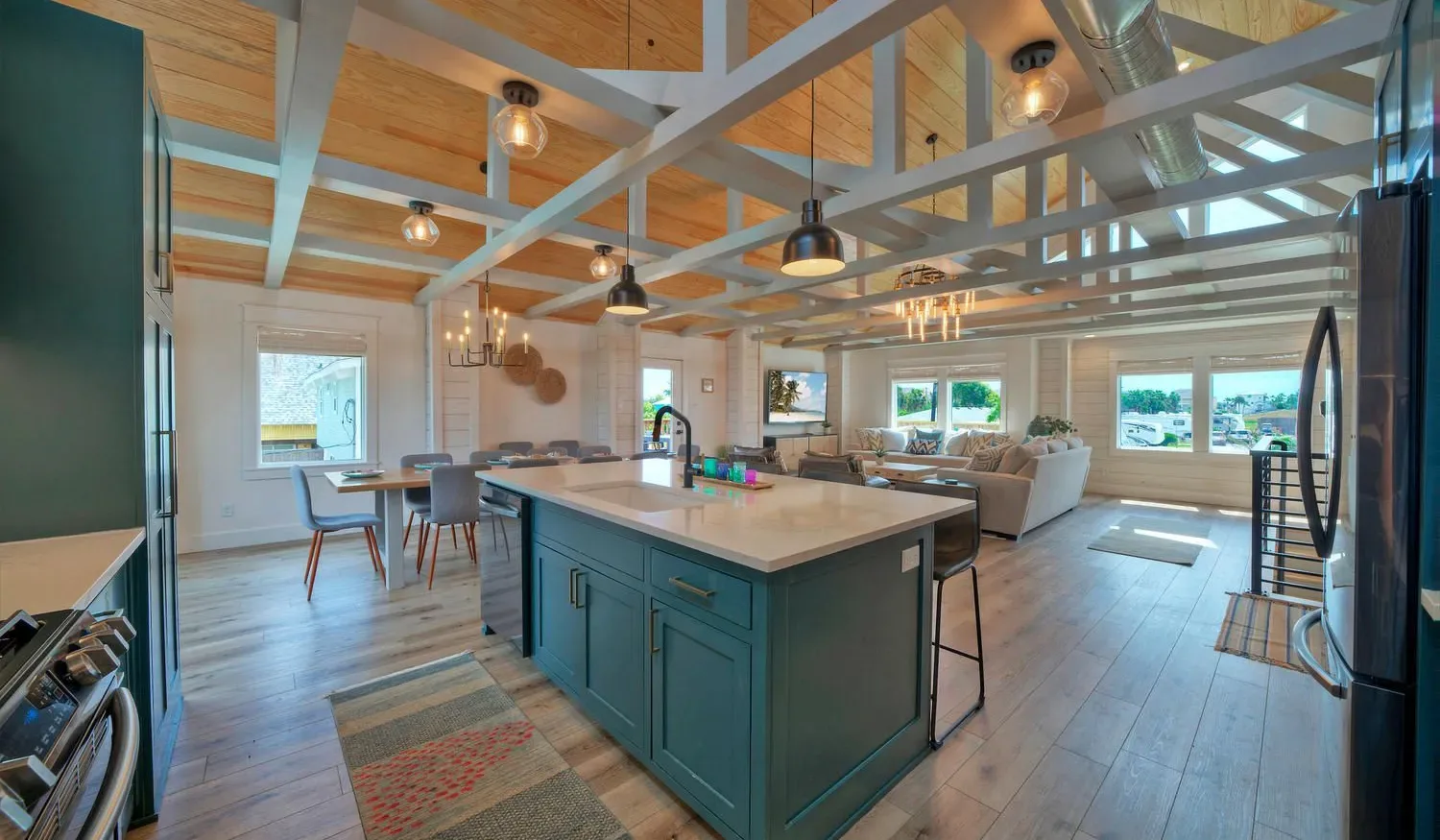 An open-plan kitchen and dining area with a large island and windows.