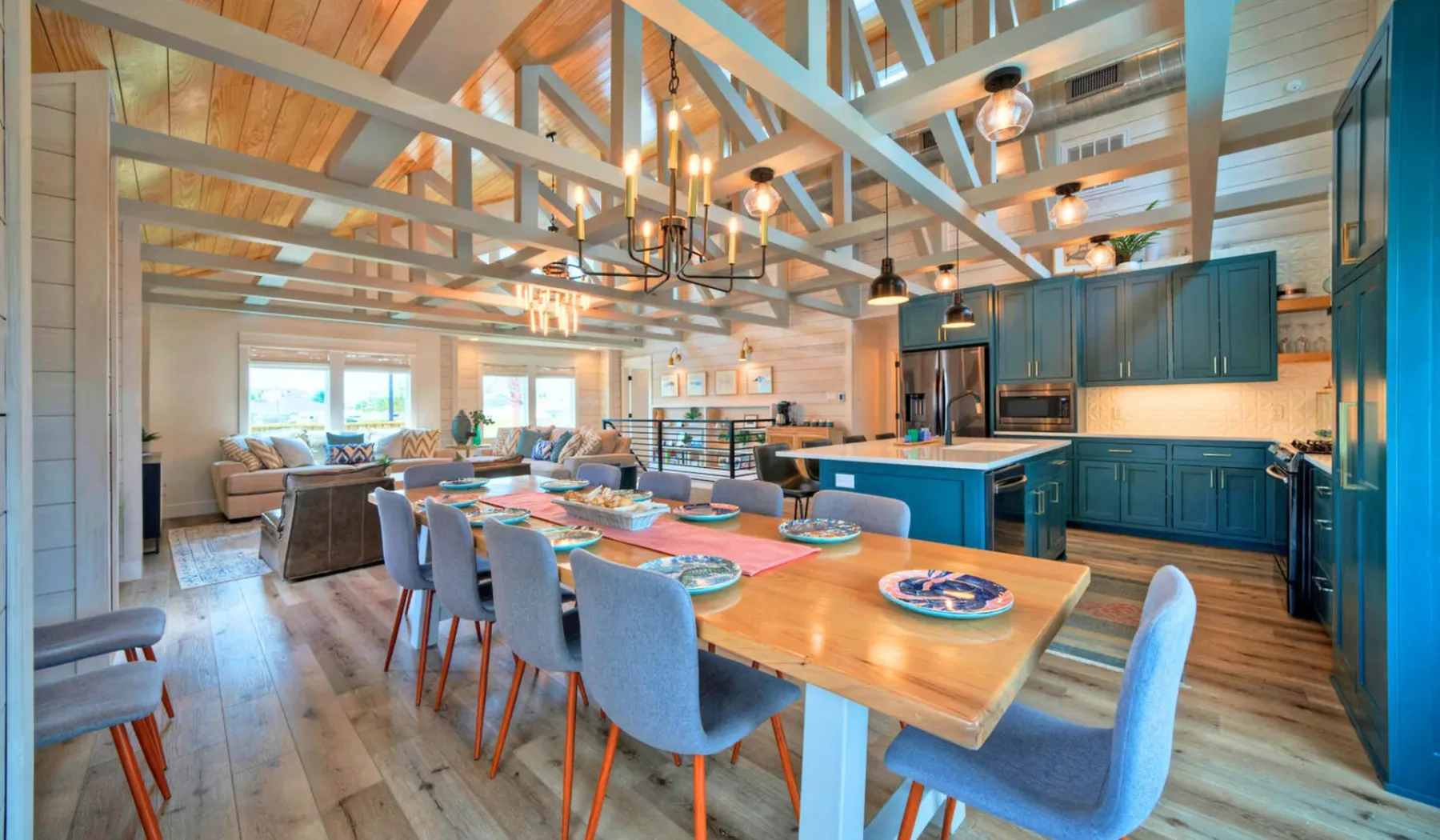 An open-plan kitchen and dining area with a long wooden table and blue cabinetry.