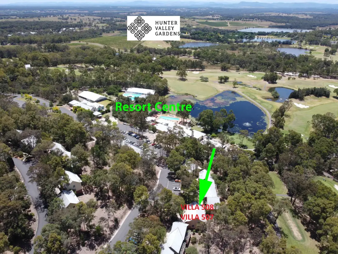 Aerial view of a resort complex surrounded by trees and landscaped grounds.