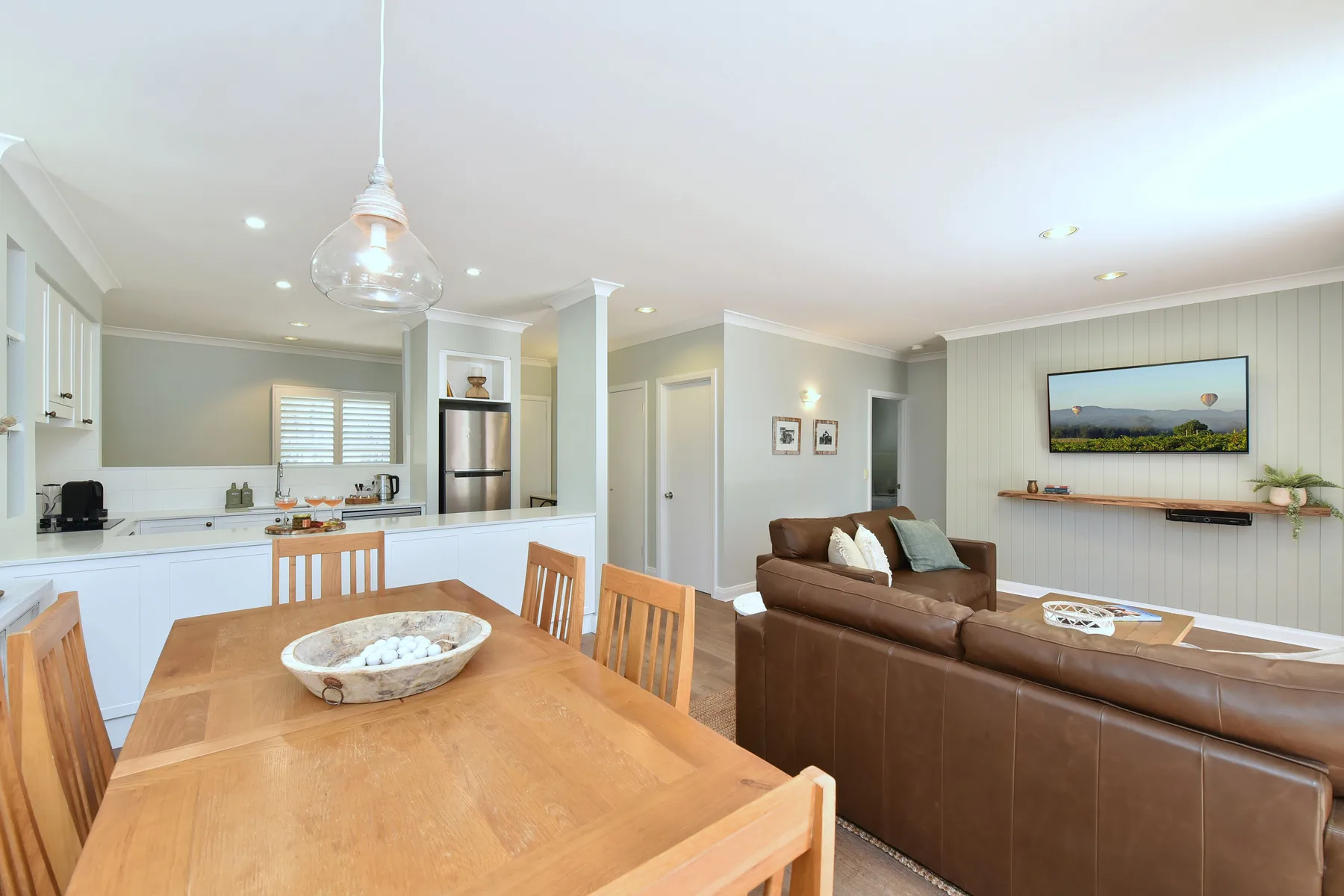 An open-plan living and dining area with a kitchen, dining table, and seating.