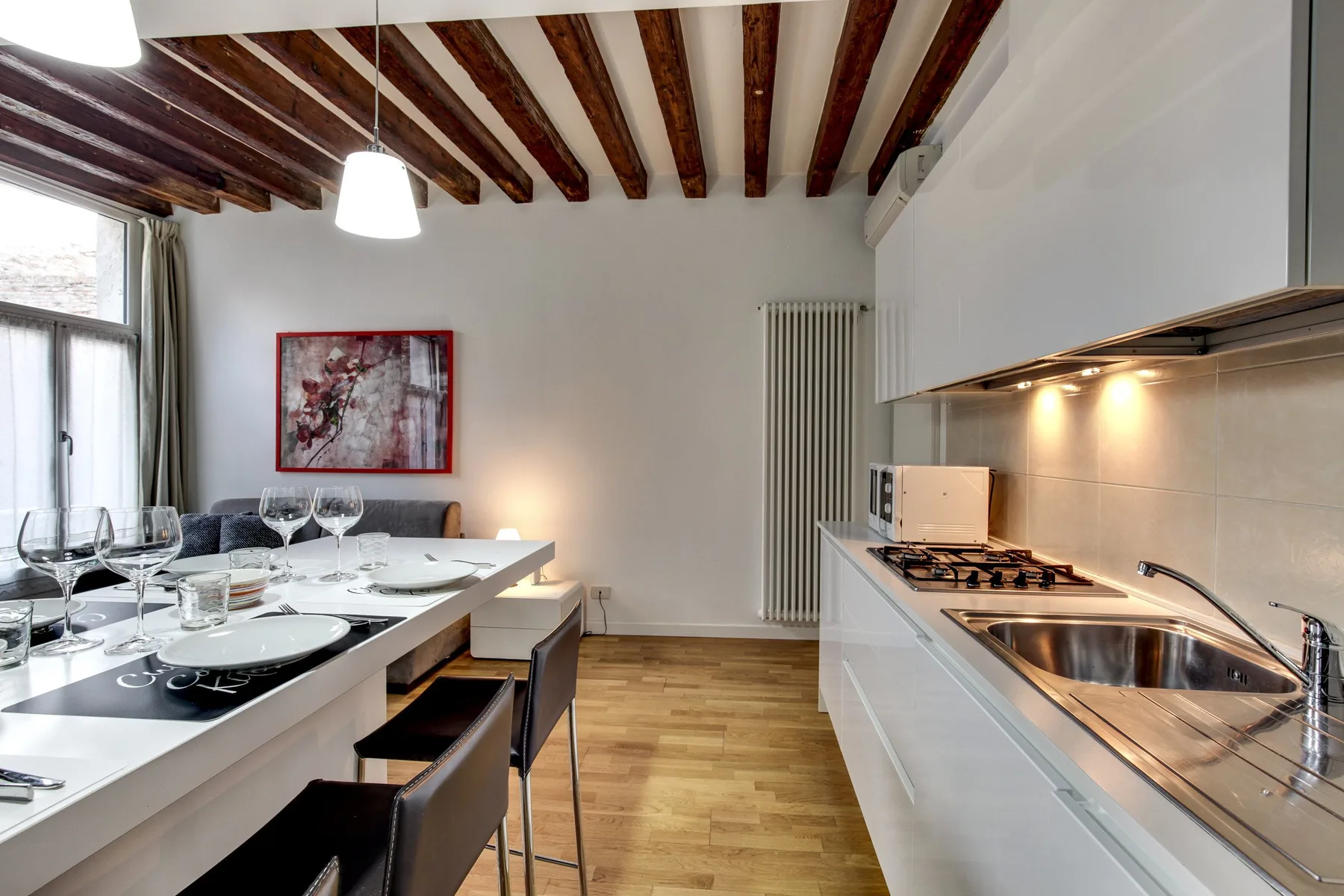 A bright kitchen and dining area with a long table beside the kitchen counter.
