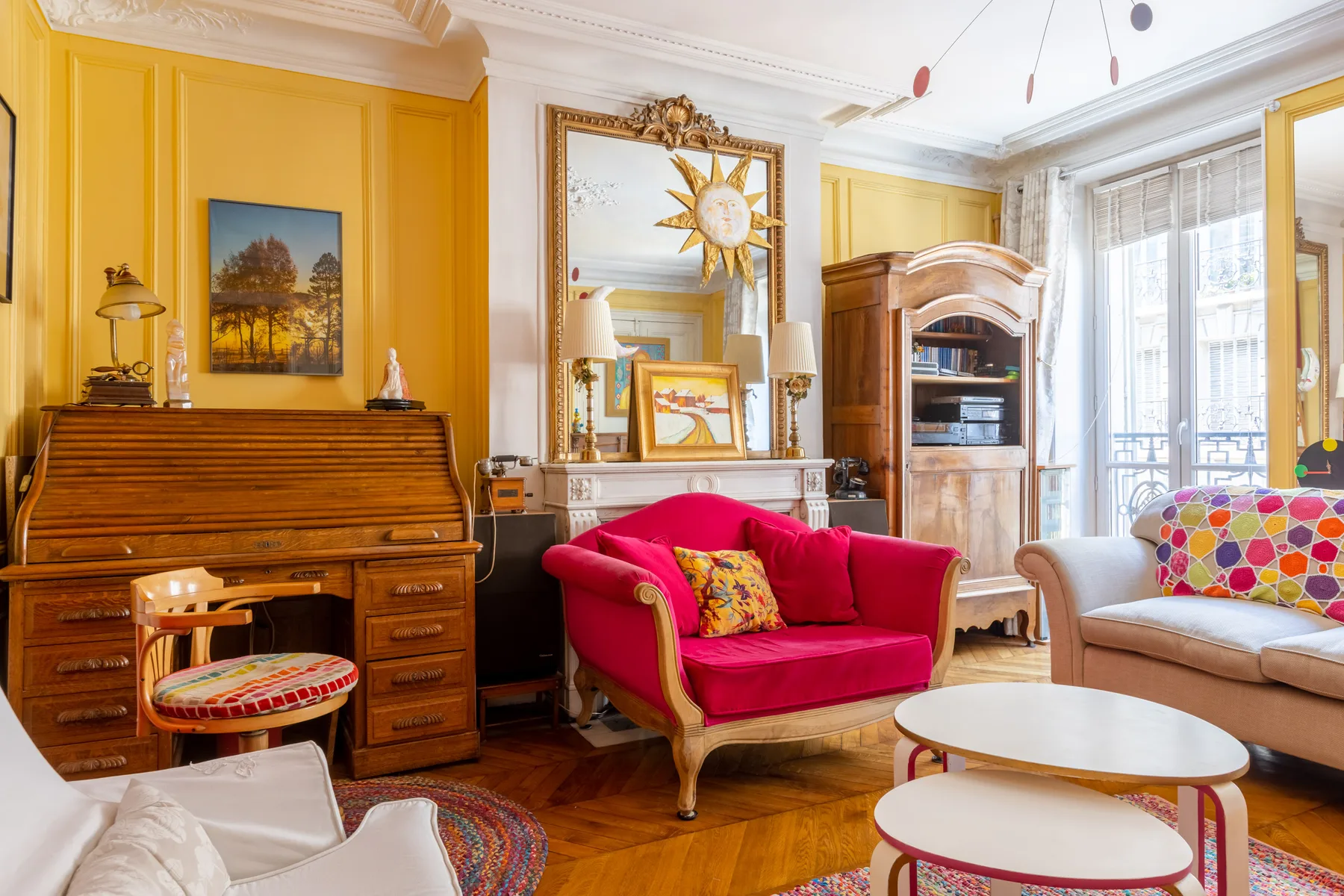 A colorful living room with a bright pink sofa and a wooden piano.