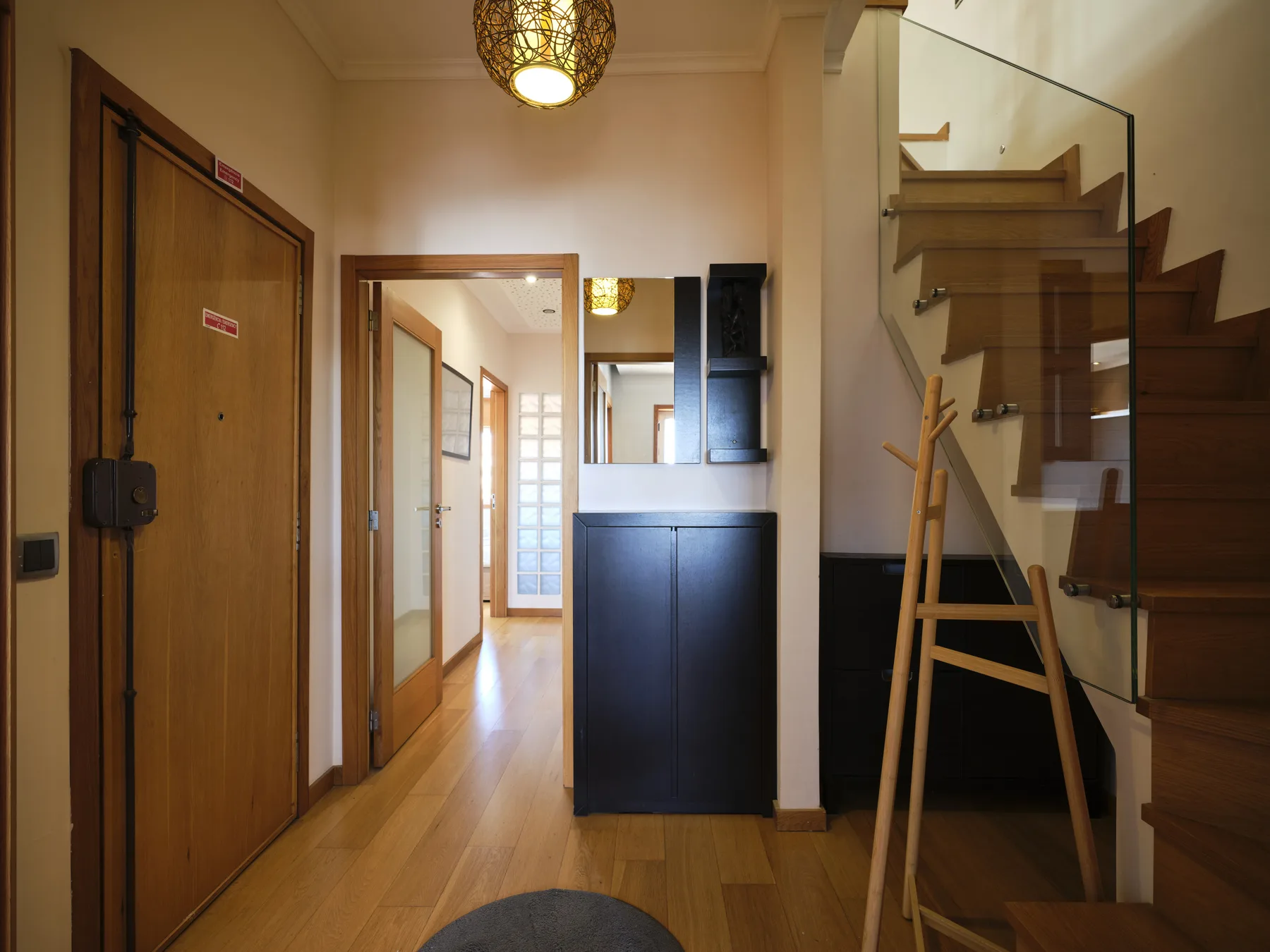 An interior hallway with wooden doors and a staircase.