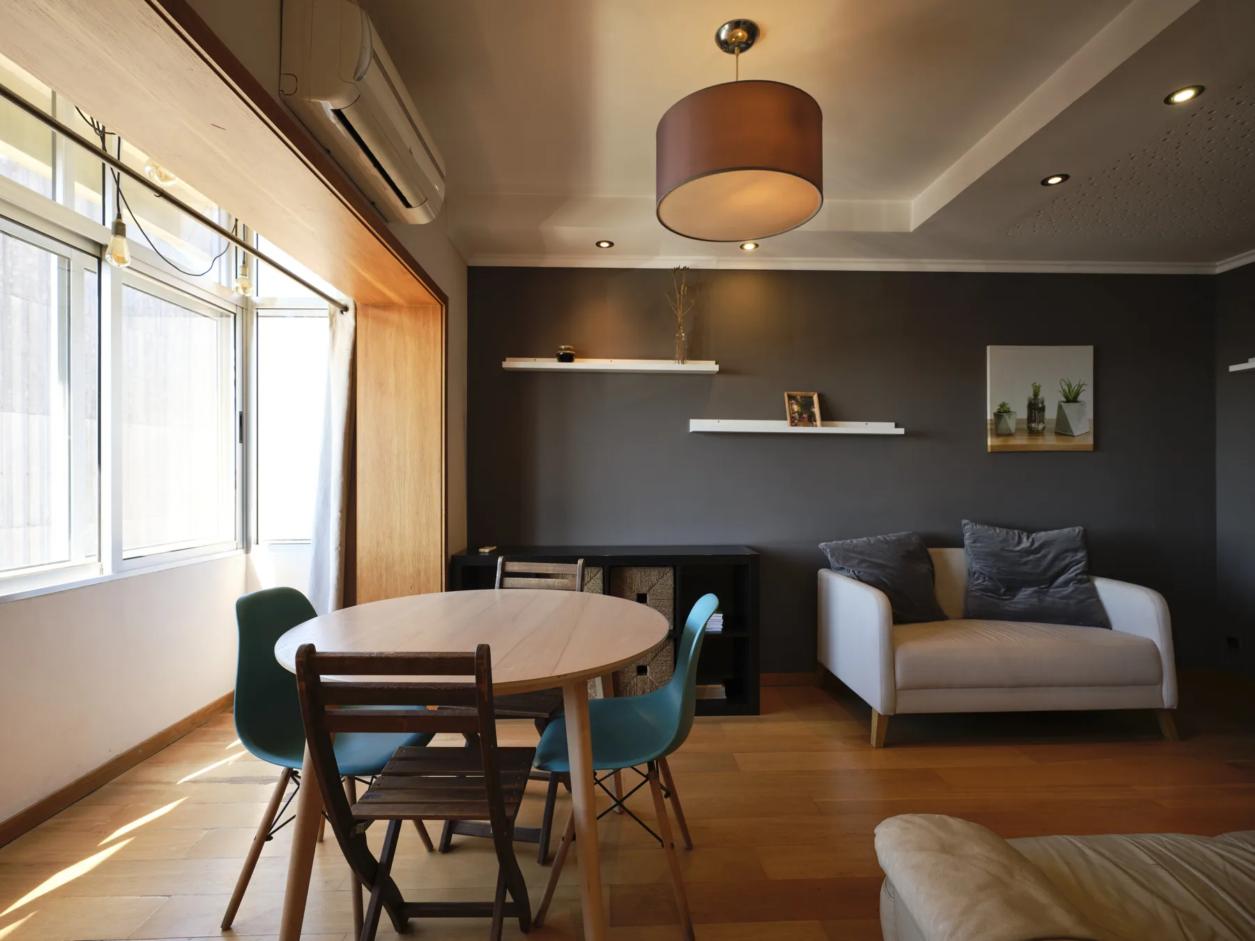 A living and dining area with a round table, chairs, and a sofa.