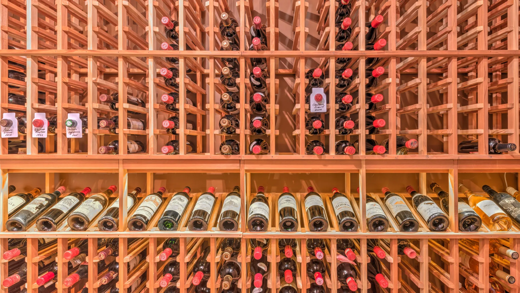 Una bodega con botellas guardadas en estantes de madera.